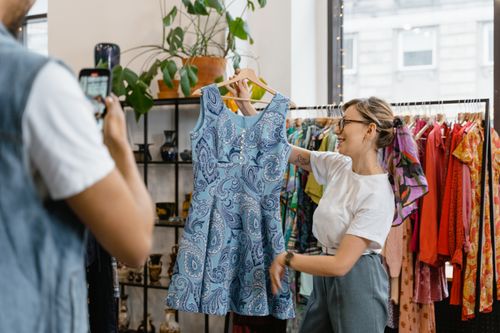 Someone photographing a dress for resale, illustrating a Vinted and Depop listing service