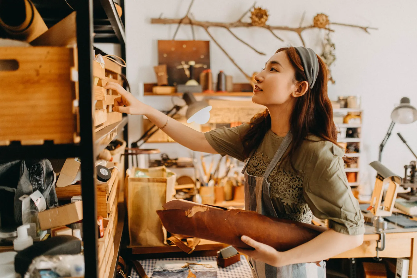 A maker working on a handmade product in a small creative workspace