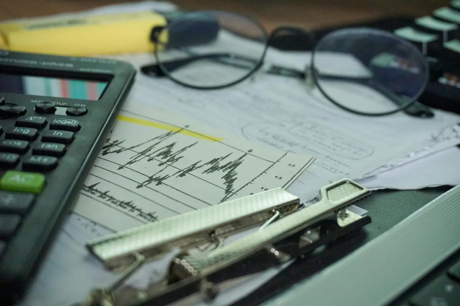 A calculator and notebook arranged on a desk for simple money planning